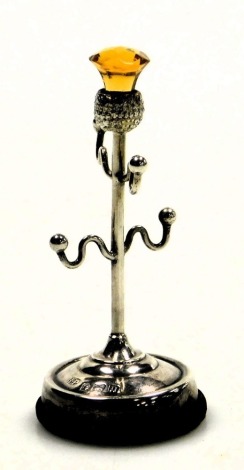 A George V silver and amber glass ring stand, with a thistle terminal and four branches, raised on a circular base, Robert Pringle, Birmingham 1912.