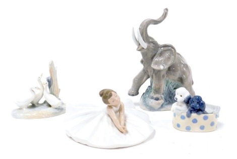 A Nao porcelain figure of a seated ballerina, figure group of three ducks, an elephant, and two puppies in a basket. (4)(AF)