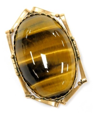 A Tigers Eye brooch, set in yellow metal, with a pendant suspension, stamped 9ct.