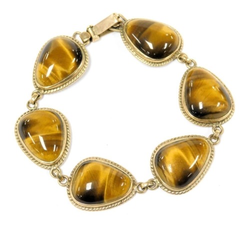 A Tigers Eye bracelet, set with six links, on a snap clasp, stamped 9ct.