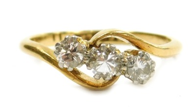 A diamond three stone ring, in a crossover setting, stamped 18ct and plat, approx. ½ct, size L, 2.6g.