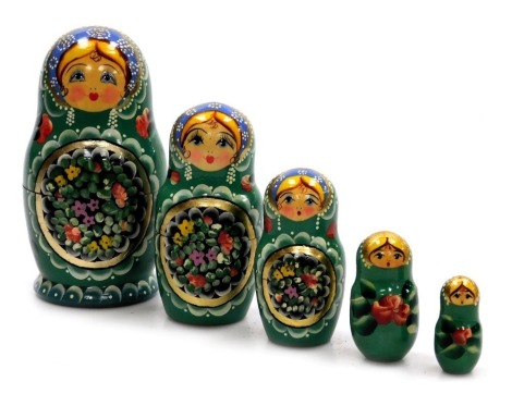 A Russian Matryoshka set of five nesting dolls, each floral painted on a green ground, largest doll 17cm high.