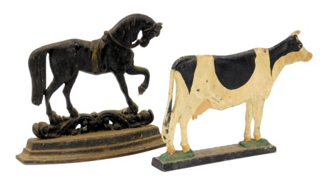 A Victorian cast iron doorstop, modelled a prancing horse, 29cm wide, and a painted cast iron doorstop, modelled as a cow, 33cm wide. (2)