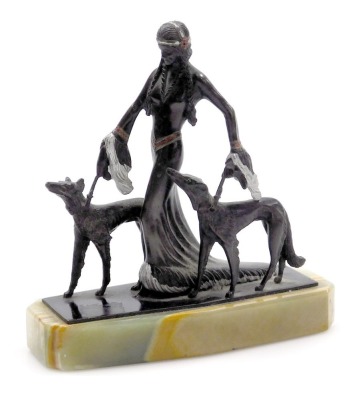 An Art Deco style cast metal figure of a semi clad lady, with two Borzois, raised on a green onyx base, 14.5cm wide.