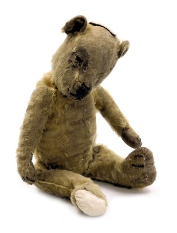 An early 20thC straw filled Teddy bear, 34cm high. (AF)