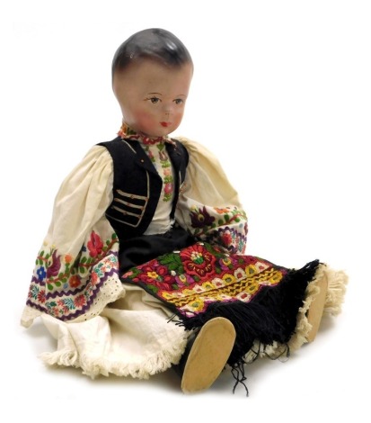 A 20thC Hungarian doll, dressed in traditional costume, with a cloth body, 51cm high.