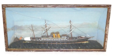 A late 19thC diorama of a sailing ship "India", modelled with three masts, sails furled and under steam, with figures on the decks, on a sea with lighthouse and blue sky beyond, glass and wooden cased, case 40cm high, 79cm wide.