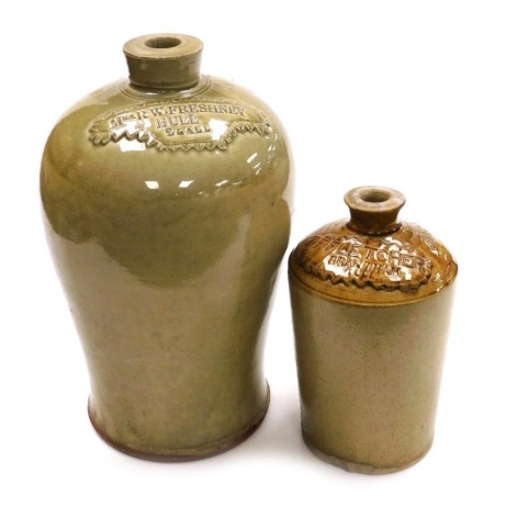 A 19thC olive stoneware two gallon jar, number 101, with raised banner named for "Mrs R W Freshney, Hull", 40cm high, and a further two tone buff stoneware gallon jar, number 3059, with raised banner named for "F Fletcher, Grantham", 26cm high. (2, AF)