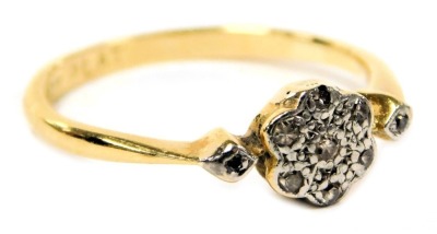 An 18ct gold platinum and diamond flower head ring, in a rub over setting, size N, 2.2g.