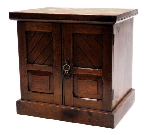 A Victorian mahogany table cabinet, with two panelled doors opening to reveal three drawers, raised on a plinth base, with key, 33cm high, 34cm wide, 26.5cm deep.