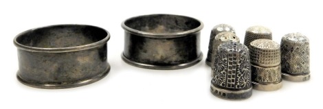 A pair of George V silver napkin rings, Birmingham 1924, and six silver thimbles, 1.45oz.