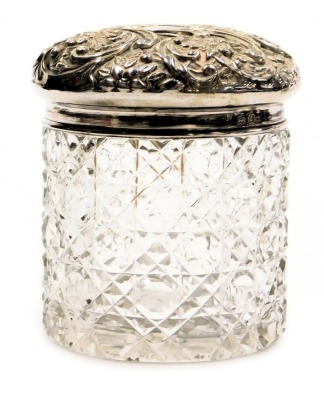 An Edward VII cut glass and silver lidded dressing table jar, embossed with flowers and scrolling leaves, vacant reserve, Birmingham 1903, 0.86oz.