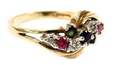 A 9ct gold diamond sapphire emerald and ruby ring, in a crossover setting, size N, 2.2g.