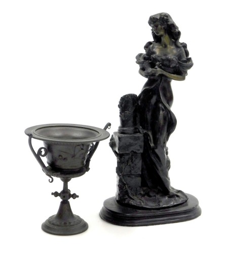 A 19thC patinated metal figure of a lady, modelled standing holding a bird, beside a plinth, raised on an oval base, 31.5cm high, together with a late 19thC bronze twin handled urn, embossed with dragonflies, 14cm high. (2)