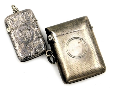 A George V silver vesta case, with engine turned decoration, vacant circular reserve, Birmingham 1911, together with a further vesta case, with foliate engraving, circular reserve monogram engraved. (2)