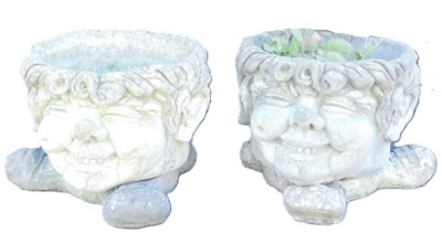 A pair of novelty concrete planters, each modelled as a smiling faun, raised on three shoed feet, 29cm high, 35cm diameter.