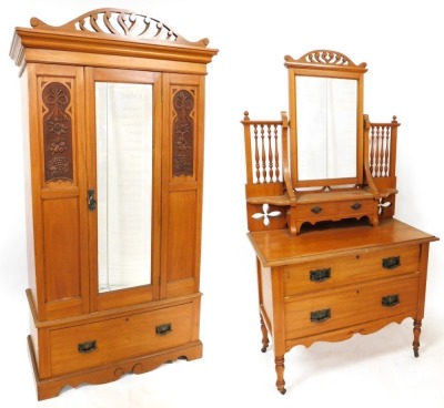 A Victorian satin walnut double wardrobe, with a scroll carved pediment, above a central door with rectangular bevelled mirror glass plate, flanked by fruit and flower carved panels, opening to reveal a hanging rail and hooks, above a frieze drawer, raise