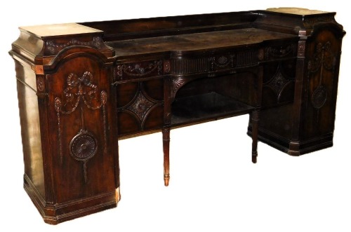 A late Victorian Adam style mahogany break front sideboard, by Gillows of Lancaster, with a galleried back, above a curved central drawer flanked by two further drawers, over a pair of cupboard doors and central recess, flanked by two doored integral pede