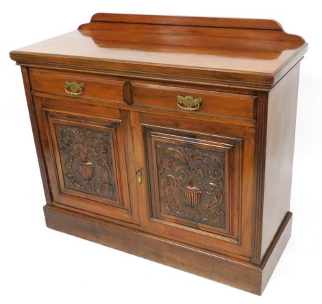 A Victorian mahogany sideboard, with a pair of frieze drawers over carved panelled doors, raised on a plinth base, 105cm high, 123cm wide, 50cm deep.