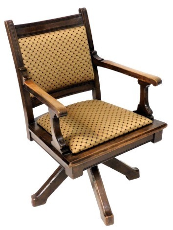 A late Victorian oak rocking office chair, with padded back and drop in seat, raised on a metal rocking mechanism above four out swept legs, 58.5cm wide.