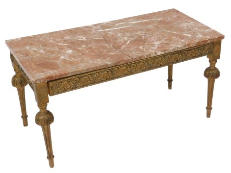 A marble topped giltwood coffee table, with a foliate carved frieze raised on leaf carved and fluted legs, 48cm high, 96.5cm wide, 46cm deep.