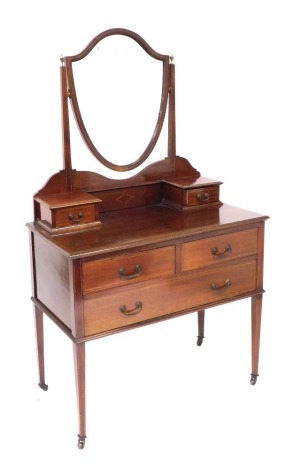 An Edwardian mahogany dressing chest, with a shield shape swing mirror, within a super structure of two small drawers, above two short over one long drawer, raised on tapering square legs, brass capped on castors, 157cm high, 92cm wide, 48cm deep.