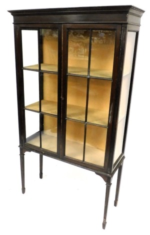 A late Victorian mahogany display cabinet, the out swept pediment over a pair of astragal glazed doors, enclosing two shelves, raised on reeded tapering square legs, on spade feet, 161.5cm high, 91cm wide, 35cm deep.