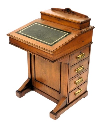 A Victorian mahogany davenport, with a fitted box top, and gilt tooled leather slope, opening to reveal an interior with three drawers, above four drawers and four dummy drawers, raised on a plinth base, 83cm high, 53cm wide, 53cm deep.