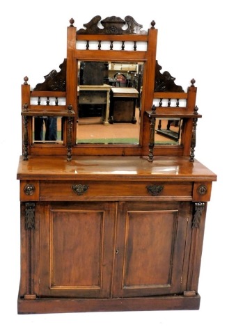 A Victorian walnut mirror back sideboard, with a central bevelled rectangular glass plate, flanked by two smaller glass panels, backed by two shelves raised on turned supports, over one long frieze drawer over a pair of cupboard doors raised on a plinth b