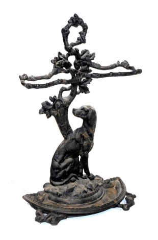 A Victorian cast iron stick stand, cast with a dog and oak tree back, above a semi circular drip tray, raised on branch feet, 70cm high.