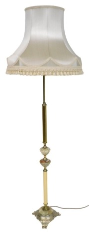 A late 20thC brass and green onyx standard lamp, with a cream silk shade, 170cm high.