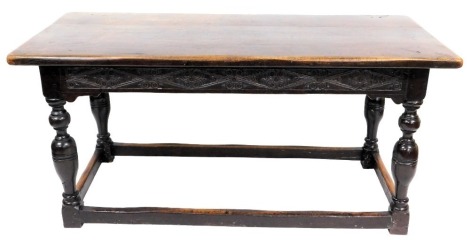 An 18thC oak refectory dining table, with a floral carved frieze, raised on turned and cup and cover supports united by a box stretcher, 78cm high, 170cm wide, 72cm deep.