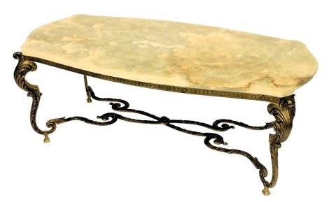 A late 20thC onyx and brass coffee table, with a serpentine top, raised on four leaf scroll cabriole legs, united by a X shaped stretcher, 45cm high, 115cm wide, 58cm deep.