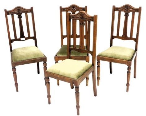 A set of four late Victorian mahogany single dining chairs, with a floral carved crest rail, green draylon drop in seats, raised on turned legs.