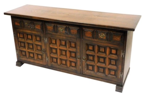 A Younger oak sideboard, with three frieze drawers over panelled doors, raised on block feet, 75cm high, 157cm wide, 47cm deep.