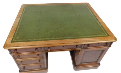 A Victorian mahogany partner's desk, with a gilt tooled green leather top, above one long and two short drawers, raised on a pedestal with three further drawers, the other with a cupboard door, the same to the other side, raised on plinth bases, 77cm high - 2