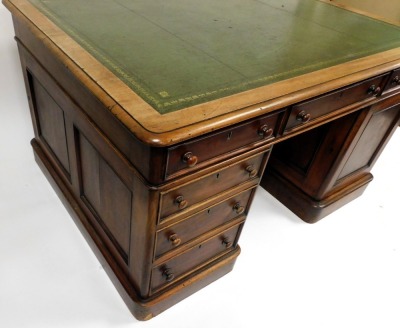 A Victorian mahogany partner's desk, with a gilt tooled green leather top, above one long and two short drawers, raised on a pedestal with three further drawers, the other with a cupboard door, the same to the other side, raised on plinth bases, 77cm high - 3