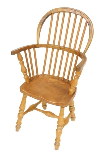 A beech and elm child's Windsor chair, raised on turned legs united a H framed stretcher, 40cm wide.