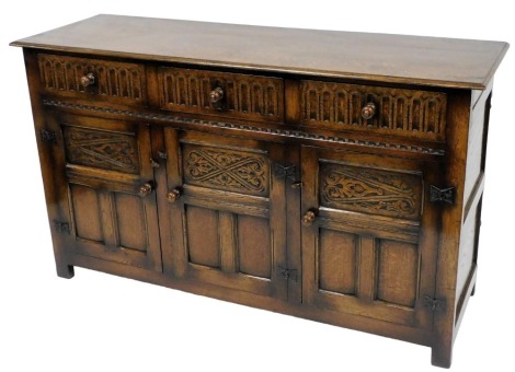 A 17thC style oak sideboard, with three frieze drawers, over panelled cupboard doors, raised on stiles, 90cm high, 153cm wide, 49cm deep.