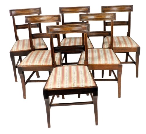 A set of Regency mahogany bar back single dining chairs, with drop in seats, raised on sabre legs.