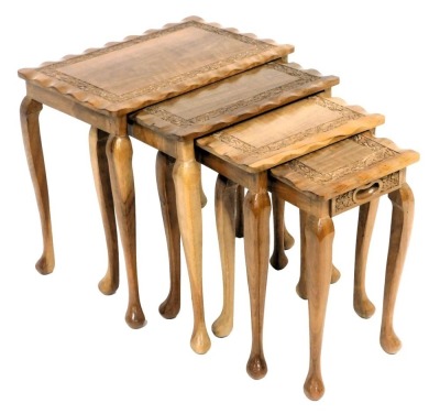 An early 20thC quartetto of Anglo Indian occasional tables, with leaf carving, raised on slender cabriole legs, largest table 45cm high, 46cm wide, 30cm deep.