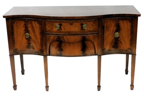 A Georgian reproduction mahogany serpentine fronted sideboard, with two central drawers, flanked by cupboard doors, raised on tapering square legs, on spade feet, 94cm high, 153cm wide, 58cm deep.