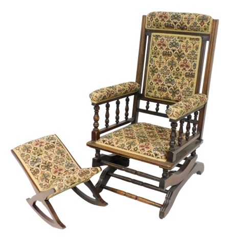 A Victorian oak American rocking chair, upholstered in floral tapestry fabric, 59cm wide, together with a footstool. (2)