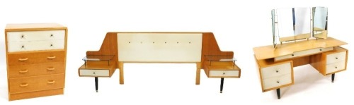 A mid century G-Plan bedroom suite, designed by E Gomme, comprising, a dressing table with a triptych mirror above one long drawer, over two pedestals each with two drawers, raised on brass capped turned legs, 135cm high, 124cm wide, 47cm deep, a double h