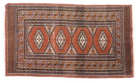 A Caucasian red ground wool rug, with four central medallions, within repeating floral and geometric borders, 159cm x 91cm.