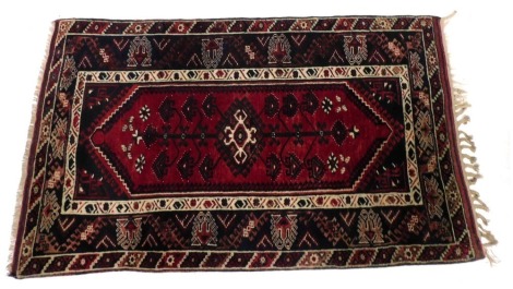 A Turkish red ground rug, decorated with a tree of life, within floral and foliate borders, 205cm x 126cm.