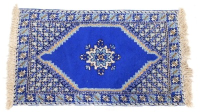 A Moroccan blue ground rug, the central field with a single medallion, within repeating geometric borders, 160cm x 83cm.