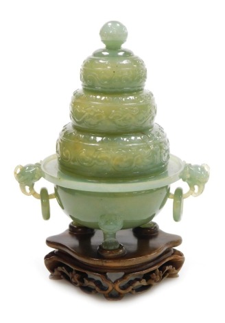 A Chinese jade incense burner, of five tiered construction, with carved scrolling decoration, on stand, boxed, 18.5cm high.