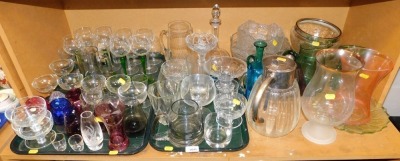 Various glassware, to include coloured glass jugs, drinking glasses, moulded glass bowls, cut glass jug, decanter, etc. (1 shelf)