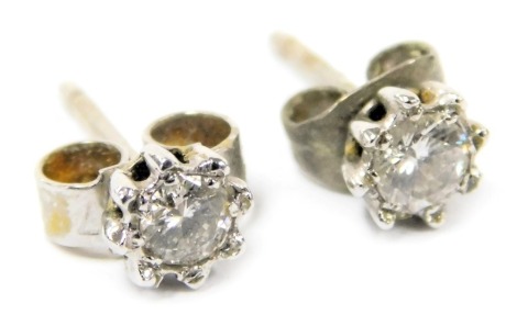 A pair of 18ct white gold and diamond single stud earrings, each approximately 1/16ct, 0.8g.